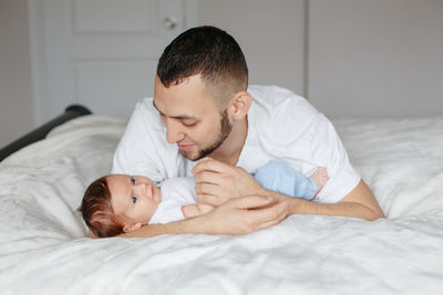 Fathers day. happy proud caucasian father with newborn baby. young man dad parent 