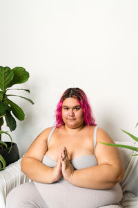 Portrait of young woman sitting on sofa at home