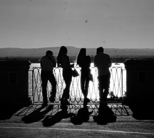 Rear view of silhouette people standing against sky