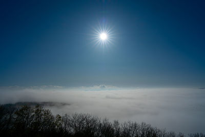 Low angle view of bright sun in sky