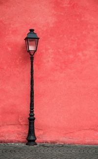 Close-up of street light against red wall