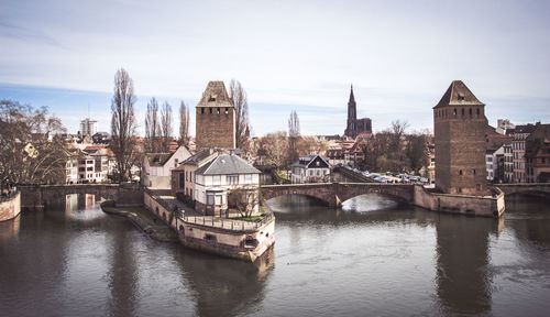 Bridge over river against buildings in city