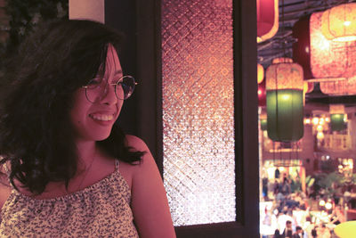 Smiling asian woman with eye glasses against the hanging chinese lanterns