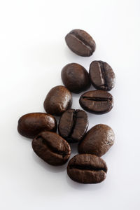 Close-up of roasted coffee beans against white background