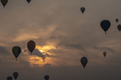 Hot air balloons flying against sky during sunset