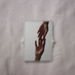 Cropped image of hands joining seen through hole