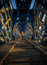 Rear view of man standing on footbridge