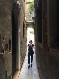 Full length of woman standing at entrance of historic building