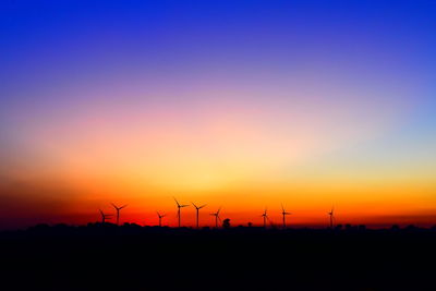 Silhouette of wind turbines at sunset