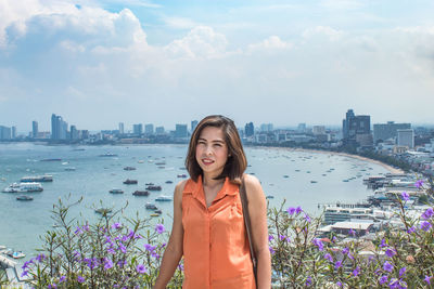 Portrait of woman standing against sea 