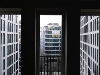 Buildings against sky seen through glass window