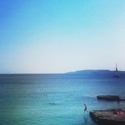 Boats in sea against clear sky