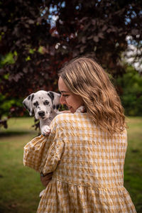 Rear view of woman with dogs on field