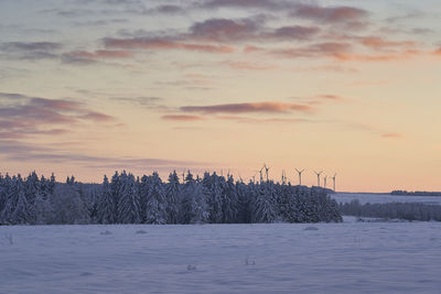 Scenic view of frozen landscape against sky during sunset