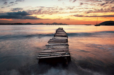 Old pier on sea at sunset