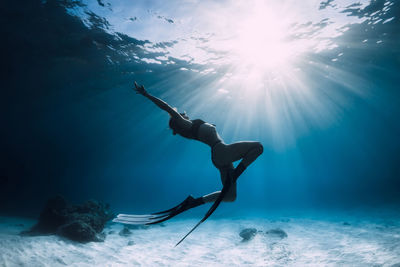 Low angle view of woman swimming in sea