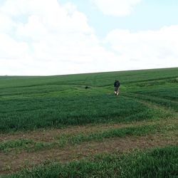 Scenic view of grassy field against cloudy sky