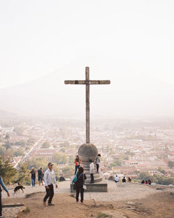 People at temple by building against sky