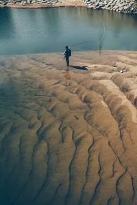 High angle view of man with backpack fishing in river