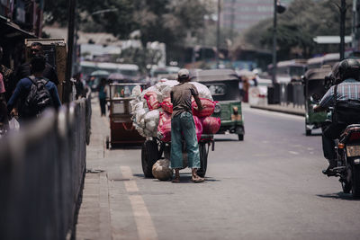 Rear view of people walking on street in city