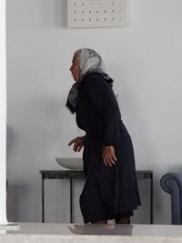 Low section of woman standing against wall