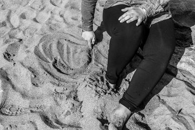 Low section of people standing on beach