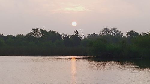 Scenic view of lake against sky at sunset