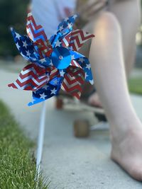 Close up of fourth of july pinwheel with young adults sitting on skateboard in the background 