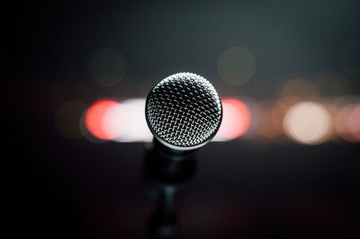 Close-up of microphone against defocused lights at night