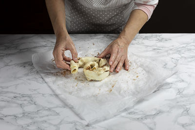 Midsection of man cutting bread