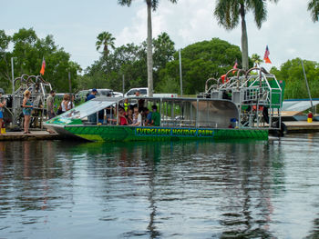 People on boat in river against sky