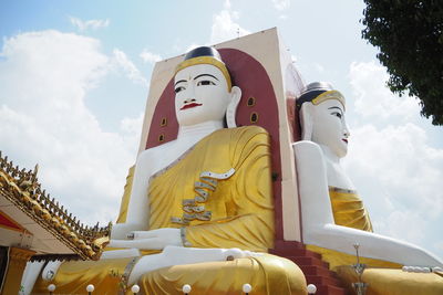 Low angle view of buddha statues against sky