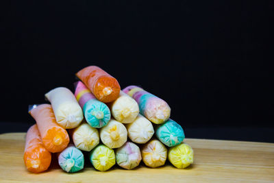 Close-up of multi colored candies on table against black background
