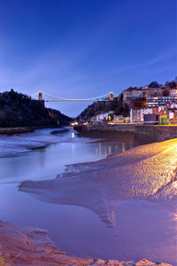 View of bridge over river at night