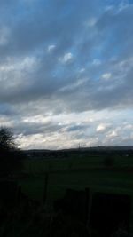 Scenic view of field against cloudy sky