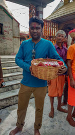 Portrait of young man holding ice cream standing outdoors