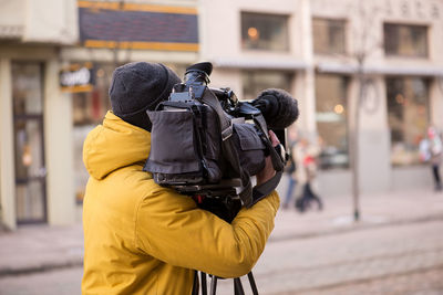 Man holding film camera in street