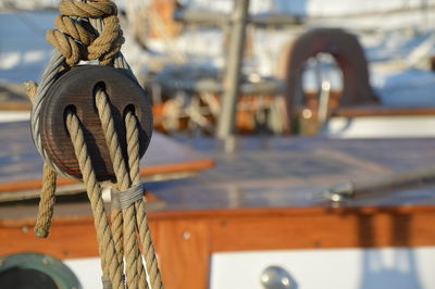 Close-up of rope tied to wooden post in sea