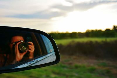 Reflection of woman in side-view mirror