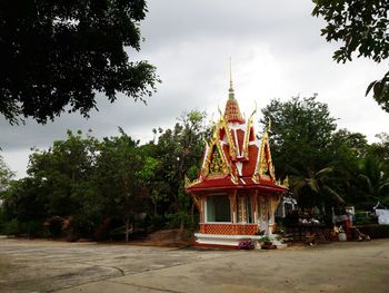 Traditional building by trees against sky