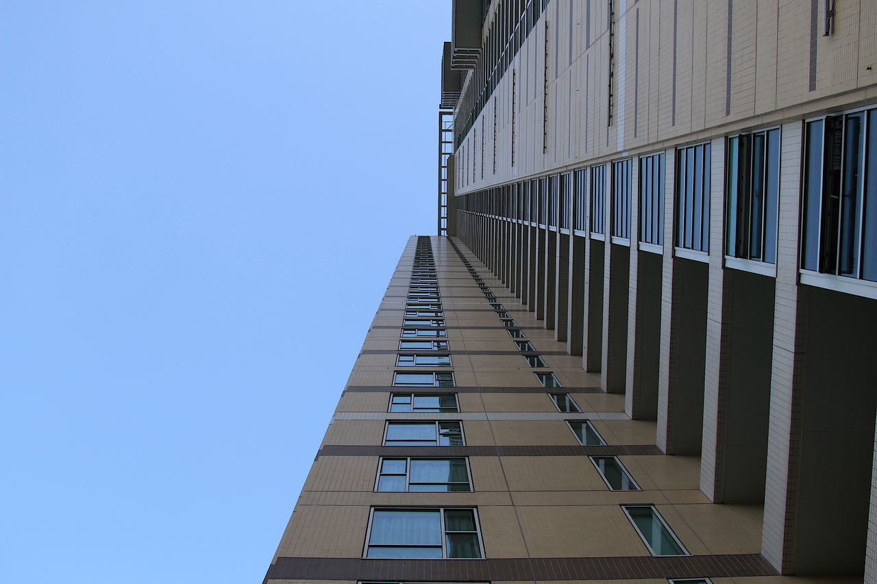 LOW ANGLE VIEW OF OFFICE BUILDING AGAINST BLUE SKY