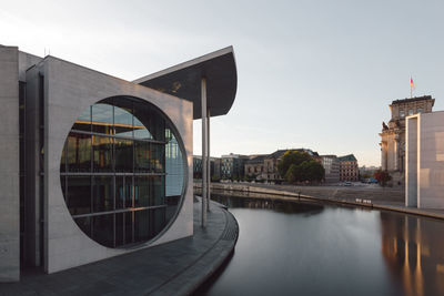 Bridge over river against buildings in city