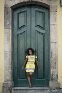 Rear view of woman standing against door