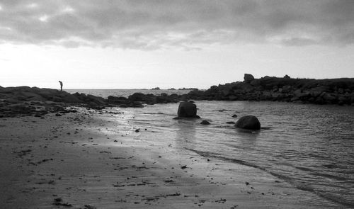 Rocks on beach against sky