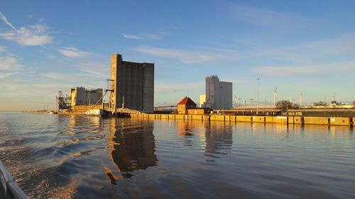 Buildings by sea against sky in city