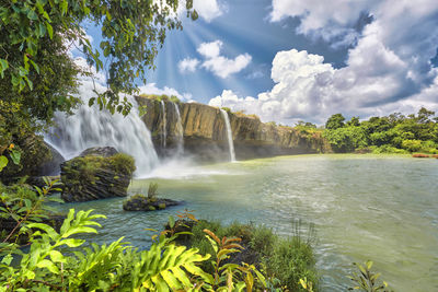 Scenic view of waterfall against sky
