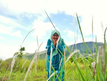 Girl standing on field against sky