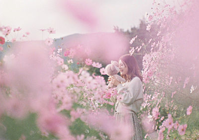 Close-up of woman standing by flowering plants