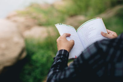 Midsection of woman reading book