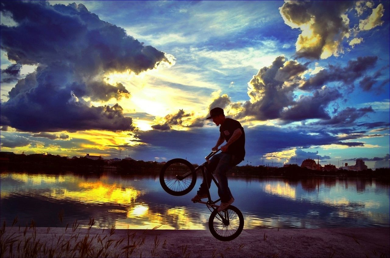 bicycle, transportation, sky, mode of transport, lifestyles, water, leisure activity, sunset, full length, land vehicle, cloud - sky, riding, men, side view, lake, cycling, cloud, nature
